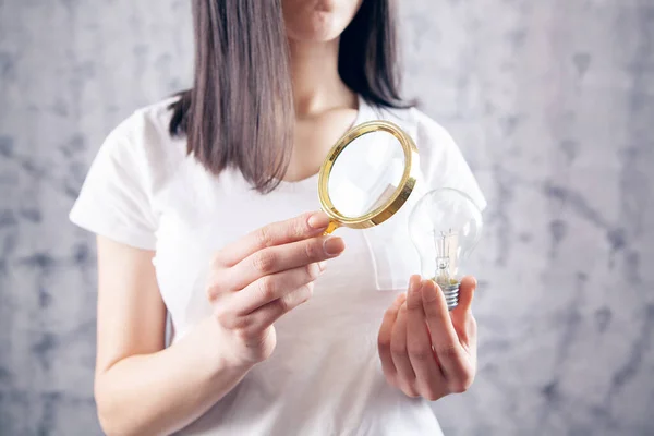 Kvinna Med Ett Förstoringsglas Tittar Glödlampa Begreppsstudie — Stockfoto