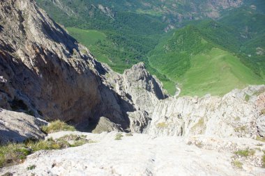 Dağdan görünen mavi gökyüzünün altındaki kayaların arasından