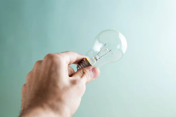 Hand Hålla Glödlampa Blå Bakgrund — Stockfoto