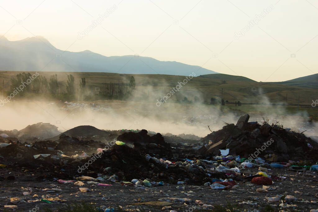 landfill fire at sunset. trash is burning