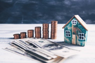 Faturalı sikkeler ve masanın üstünde bir ev.