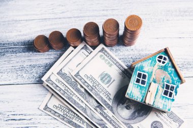 Faturalı sikkeler ve masanın üstünde bir ev.