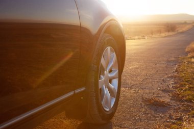 Araba tarlaların yanındaki yolda.