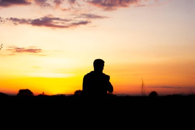 Gün batımında bir adamın siyah silueti.