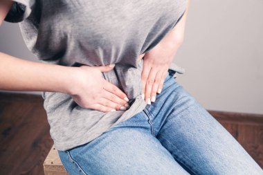 Genç bir kadının midesi ağrır.