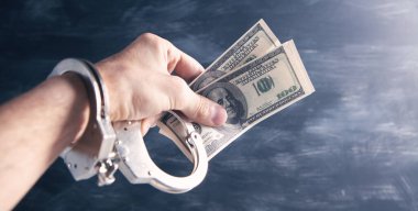 elleri kelepçeli, elinde para var.