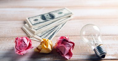 Ampul, buruşmuş kağıtlar ve para