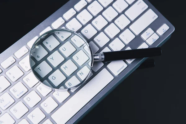 Lupe Und Weiße Tastatur Auf Dem Tisch — Stockfoto