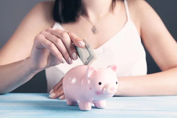 Young Woman Puts Dollar Bill Piggy Bank — Stock Photo, Image
