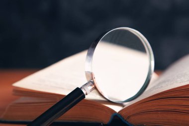 Büyüteç ve kitap masanın üstünde.