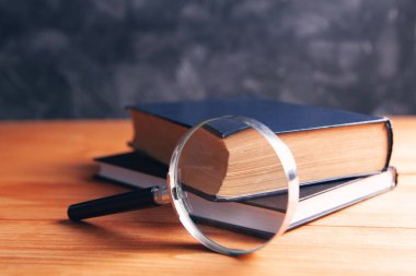 Büyüteç ve kitap masanın üstünde.