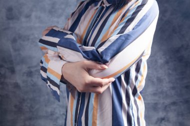 Genç bir kadının dirseği ağrıyor.