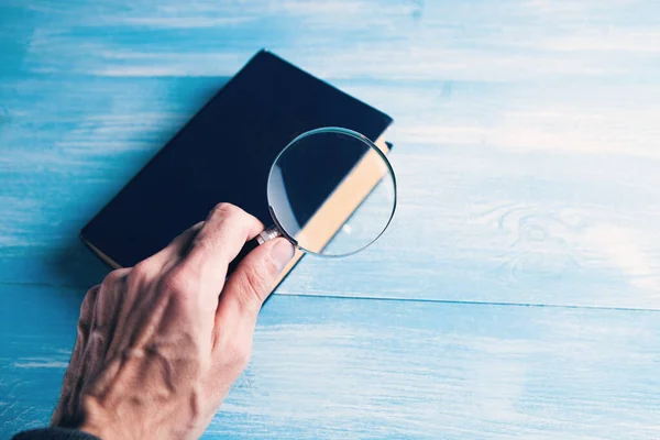 magnifying glass looking at a book on the table