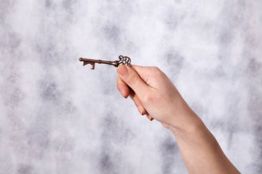 Elinde eski anahtarları tutan genç bir kadın.