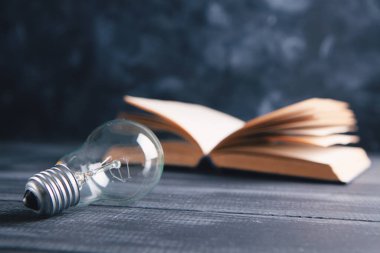 Ampul ve kitap masanın üstünde.