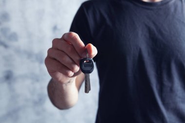 Evin anahtarlarını tutan genç adam.