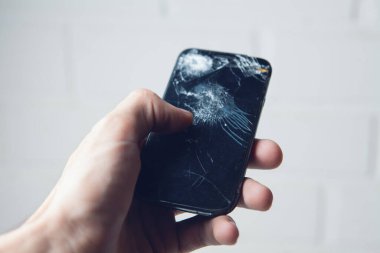 Bozuk telefonu beyaz arkaplanda tutmak