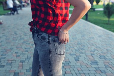 Parkta duran kot pantolonlu kız.