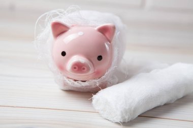 Bandaja sarılı domuz kumbarası