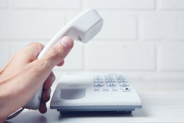 Ev telefonu ahizesini tutan el.