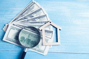 Masada para, ev ve büyüteç var.