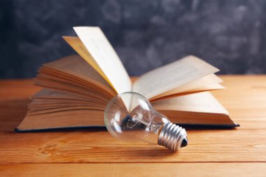 Ampul ve kitap masanın üstünde.