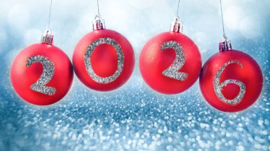 Yeni yıl 2026 'da gümüş arkaplanda kırmızı noel mücevherleri