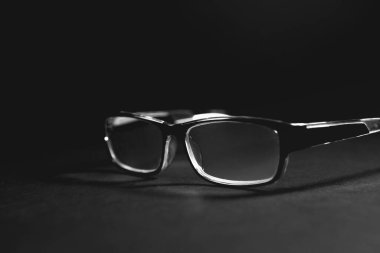 Siyah arka planda siyah ve beyaz gözlüklü fotoğraf.