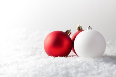 Beyaz kar zemininde kırmızı ve beyaz noel topları kopyalama alanı ile