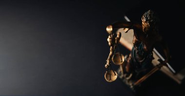 Adalet heykeli ve karanlık bir arka planda adalet terazisi..