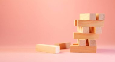 Pembe arka plan, iş ve risk konsepti üzerine ahşap blok kulesi.