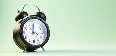 Alarm saati yeşil arkaplanda izole edildi