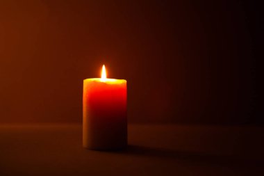 Karanlık bir arkaplanda mum yakmak.