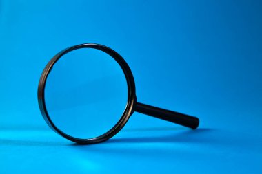 Renk arkaplanındaki cam büyüteç.