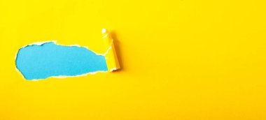 Sarı arkaplandaki mesajınız için boşluğu olan yırtık kağıt.