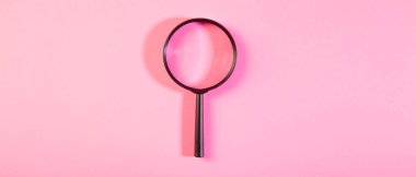 Pembe arka planda büyüteç. Kopyalama alanı olan üst görünüm.