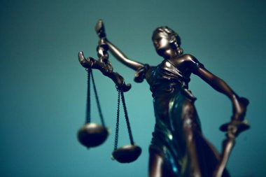 Mavi arka planda adalet terazisi olan bir adalet heykeli..