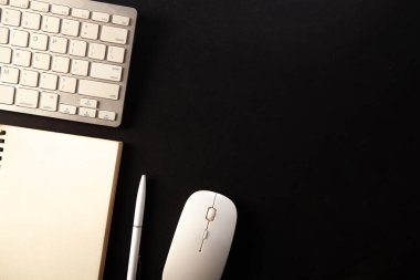 Klavyeli, fareli ve defterli ofis masası. Kopyalama alanı olan üst görünüm