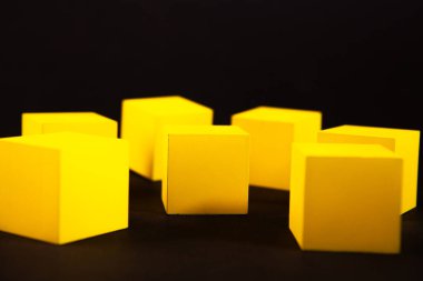 Siyah arkaplanda sarı tahta küpler, yakın plan, seçici odak