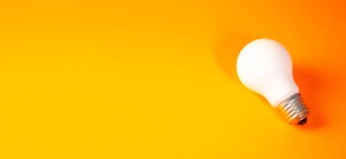 Turuncu arkaplanda parlak ampul, enerji tasarrufu kavramı.