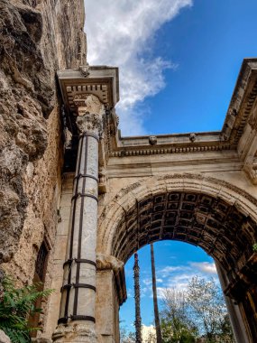 Antalya, Türkiye 'deki Hadrian Kapısı. Eski Roma zafer kemeri mermer kolonlar ve süslü tavan detaylarıyla Kaleici eski kasabasında mavi gökyüzüne karşı.