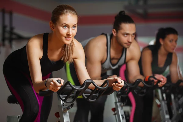 Grupp passar människor cykling i fitness-klubben — Stockfoto