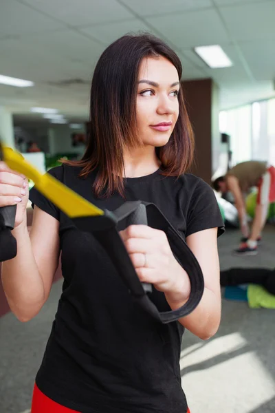 Young beautiful woman training in gym using trx fitness straps — Stock Photo, Image