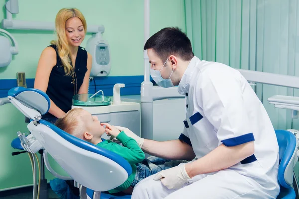 Jovem dentista trabalhando com o paciente infantil em um hospital moderno . — Fotografia de Stock