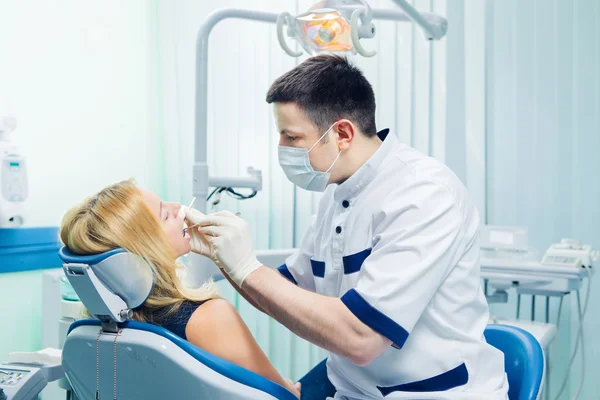 Joven rubia siendo tratada por higienista dental — Foto de Stock