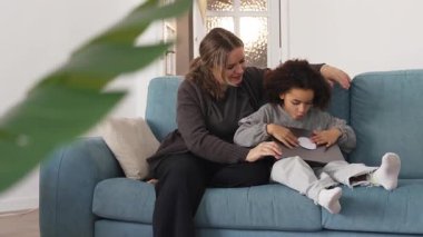 Kafkasyalı anne ve Afrikalı Amerikalı kız evde çalışıyor, çizgi film seyrediyor, rahat beyaz odada dizüstü bilgisayarlı kanepe kullanarak ödev yapıyor. Birlikte vakit geçiririz, boş zamanlarımızda