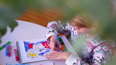 Noel Baba 'ya yeni yıl tatili için mektup yazan çocuk, rahat Noel süslemeleri ve ışıkları, renkli kalemler çizen kız, Noel Baba' ya hediyeler hazırlayan çocuk,