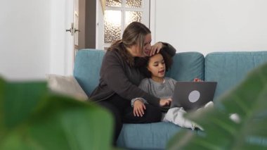 Kafkasyalı anne ve Afrikalı Amerikalı kız evde çalışıyor, çizgi film seyrediyor, rahat beyaz odada dizüstü bilgisayarlı kanepe kullanarak ödev yapıyor. Birlikte vakit geçiririz, boş zamanlarımızda