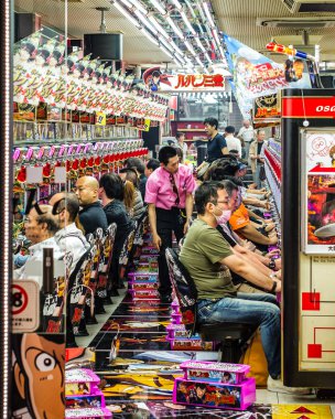 Şanslarını bir satırda slot makineleri Japonya'nın Osaka çalışan insanlar. Renkli citylife sahne.