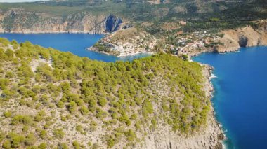 Assos Kefalonia 'daki büyüleyici bir sahil köyüne bakan çam ağacı uçurumlarının hava manzarası Yunanistan.